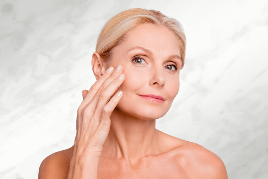 Image of mature woman with hand on face | BOTOX | GGFM Aesthetics